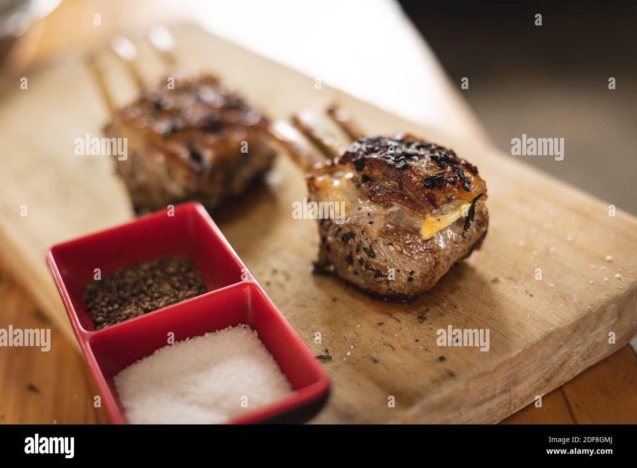 Nahaufnahme von gegrillten Rippchen und Salz-Pfeffer-Behältern Auf Holzbrett Stockfoto