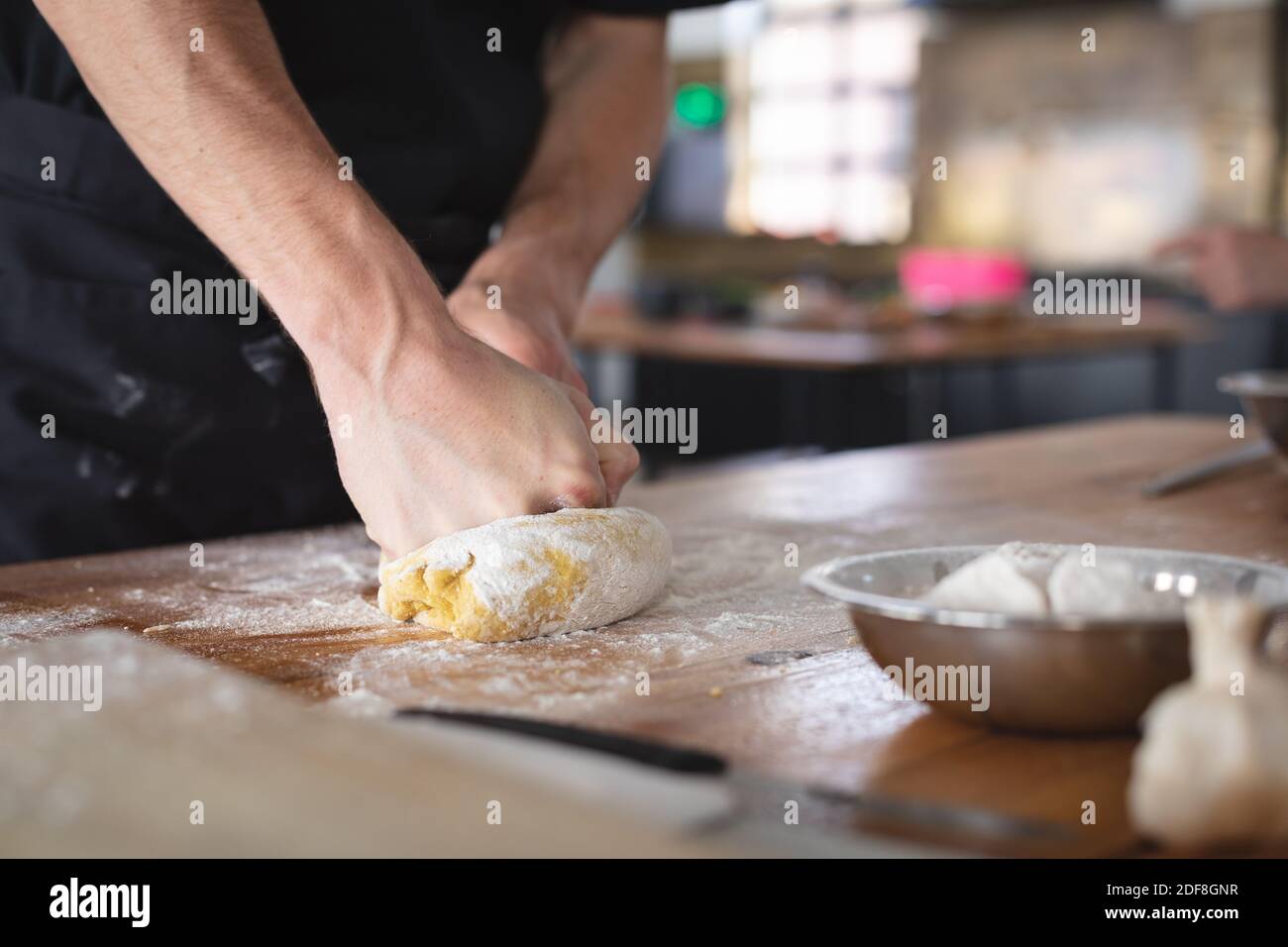 Kaukasischer Chefkoch mit schwarzer Schürze in der Küche Stockfoto