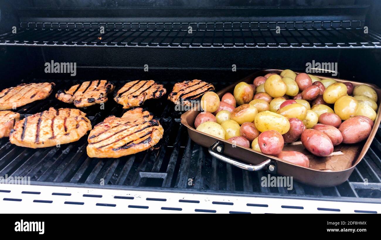 Grillen marinierten Hähnchen und kleine Kartoffeln auf einem Gasgrill im  Freien Stockfotografie - Alamy