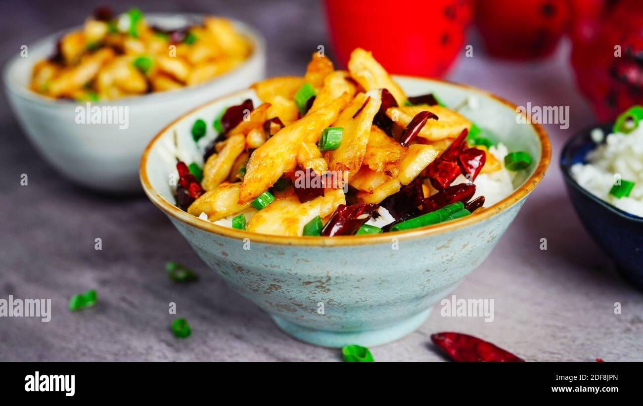 Würziger Fisch mit trockenen roten Chilis und schezwan Pfefferkorn serviert mit Jasminreis, selektiver Fokus Stockfoto