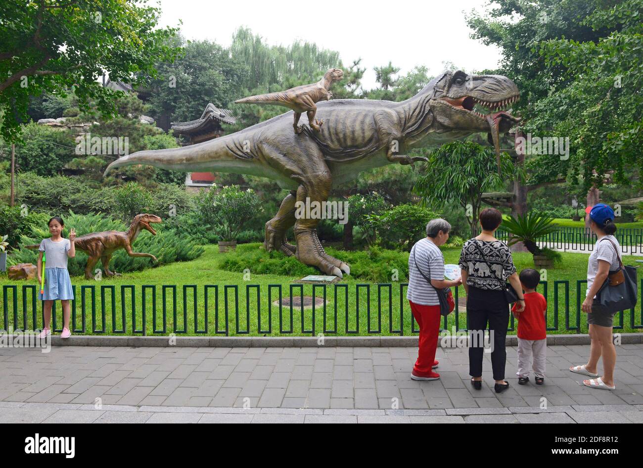 Besucher schätzen die Modelldinosaurier im Taoranting Park im Westen von Peking, China Stockfoto