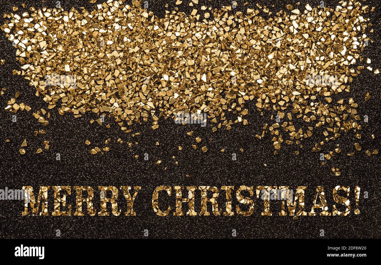 Frohe Weihnachten Goldene Glitzersteine auf schwarzem Hintergrund Stockfoto