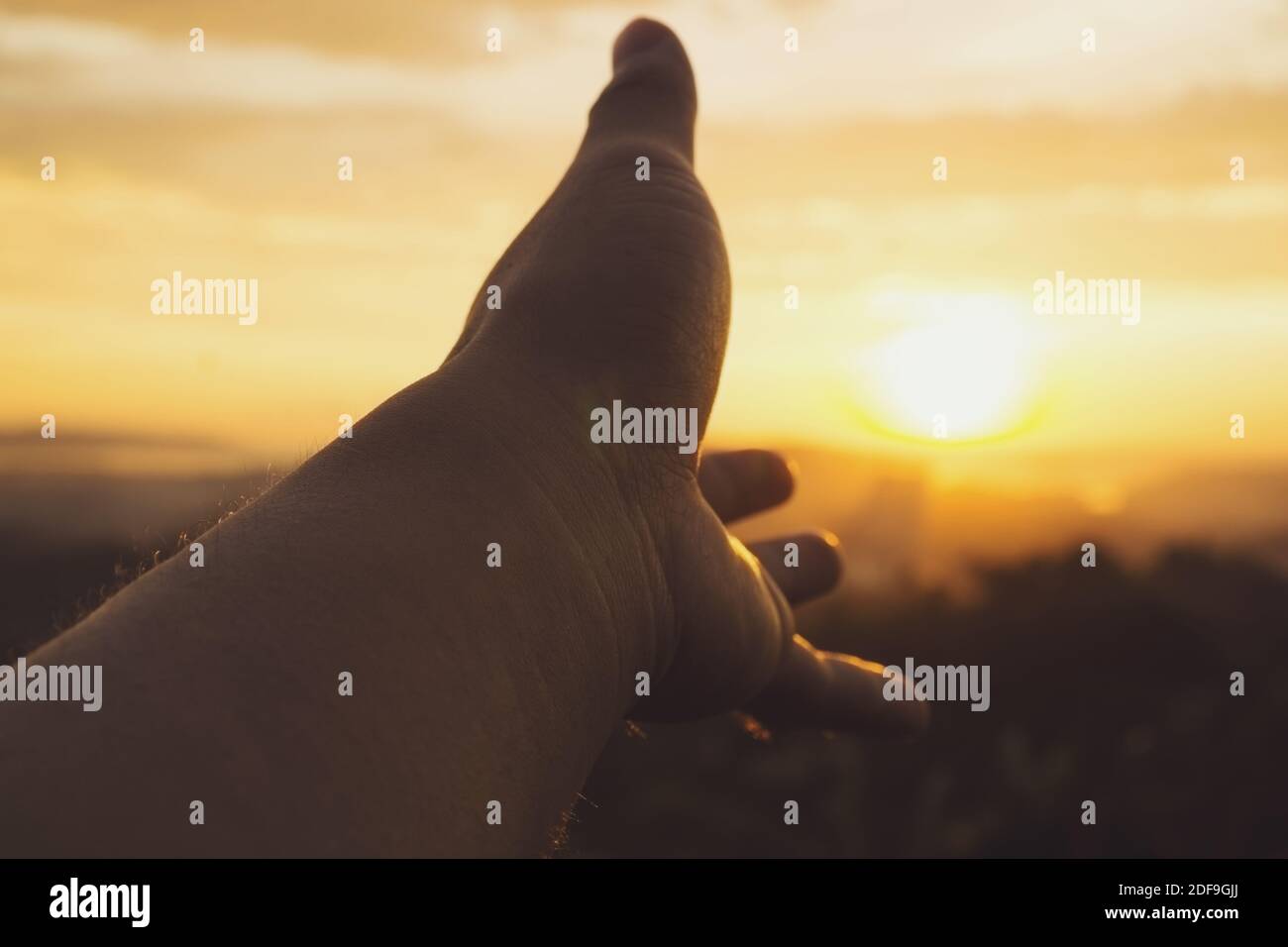 Hand gegen Sonnenuntergang Blick in der Dämmerung. Hilfe-Konzept erreichen. Stockfoto