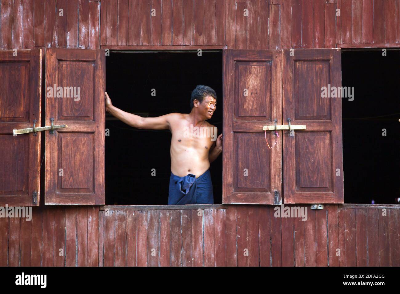 Ein Mann in das Fenster seines Hauses im Dorf des PWE SAR KONE - INLE-See, MYANMAR Stockfoto