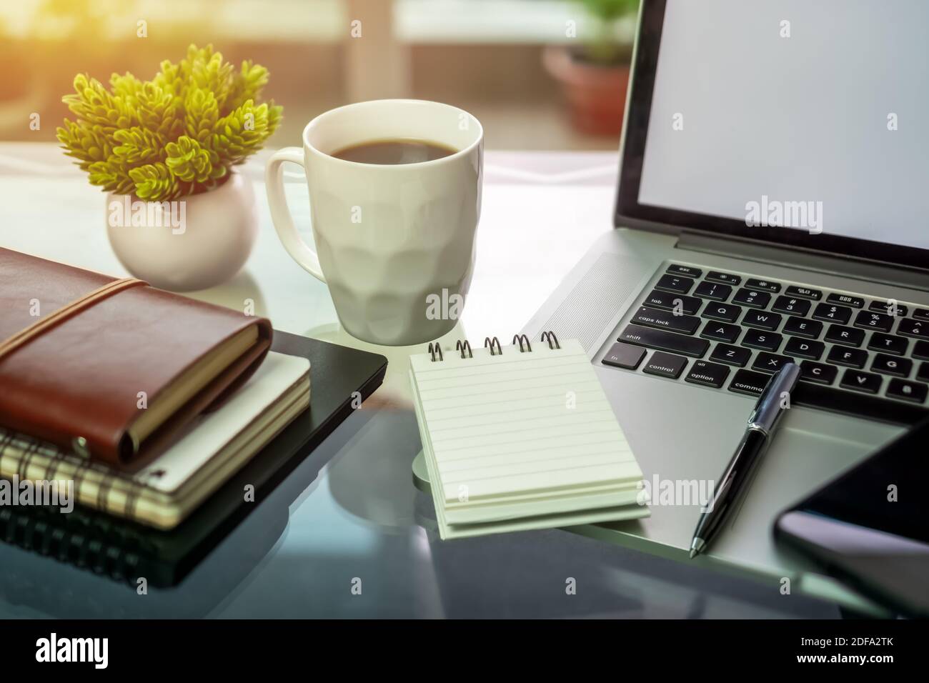 Laptop, Kaffee und Bücher auf dem Schreibtisch des Heimbüros. Stockfoto