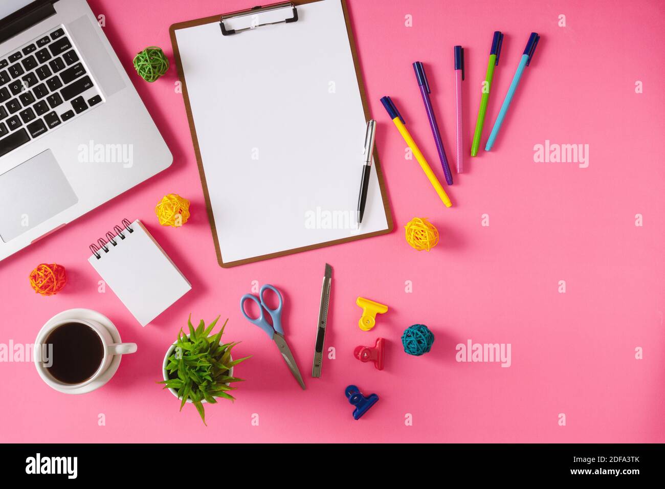 Bürobedarf, Laptop und Kaffee auf rosa Hintergrund. Bunte und lebendige Bürotisch Stillleben. Stockfoto