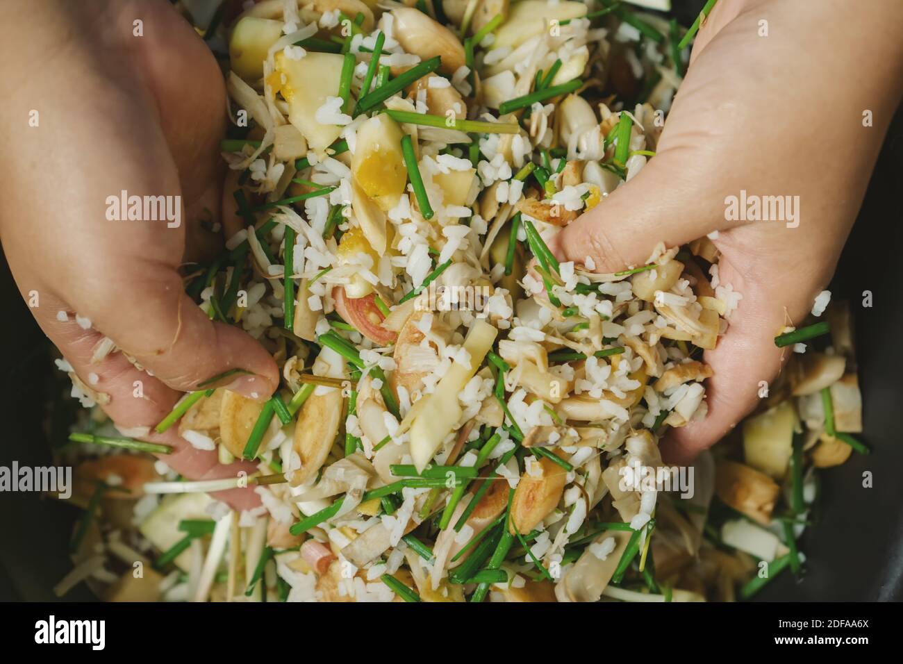 Ansicht von oben auf Hände mischen Reis und Gemüse. Authentische asiatische traditionelle Küche. Stockfoto