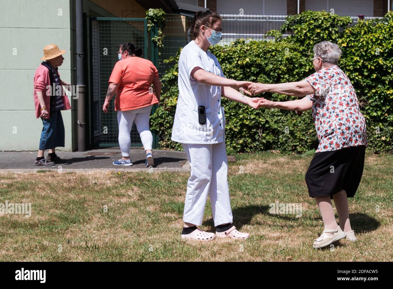 Eine Pflegekraft hält einen Wohnsitz, nachdem sie ihre Tochter am 27. Mai 2020 in einer Blase im Pflegeheim der Fondation Shadet Vercoustre in Bourbourg bei Gravelines, Frankreich, in dem eine Doppeleingangsblase installiert wurde, um Besuche ohne Kontaminationsrisiko zu ermöglichen, Im Rahmen einer prophylaktischen Maßnahme gegen die Ausbreitung der Covid-19-Krankheit durch das neuartige Coronavirus. Verwandte und Bewohner betreten das Zelt durch einen anderen Eingang, um sich im selben Raum wiederfinden, der durch eine transparente Kunststoffleinwand getrennt ist. Diese Blasen wurden ursprünglich vom Unternehmen für den Tourismus entwickelt. Foto von J Stockfoto