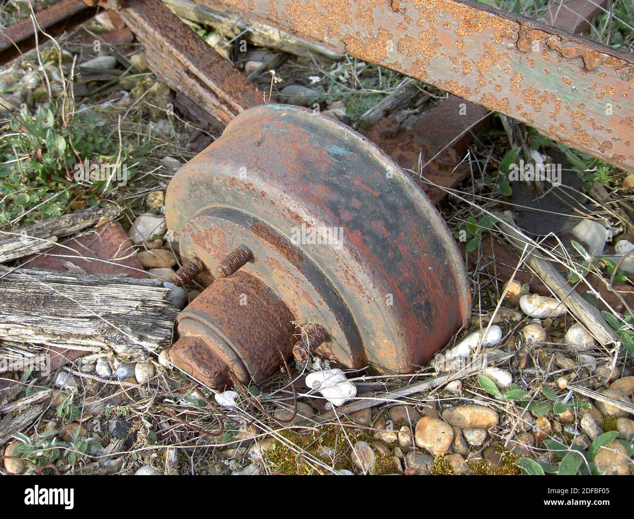 Ein altes Trolley-Rad ist am Dungeness-Strand teilweise in den Kies versenkt. Die jetzt stillgegange Schiene pflegte, den Fischfang über dem Schindel zu holen. Stockfoto