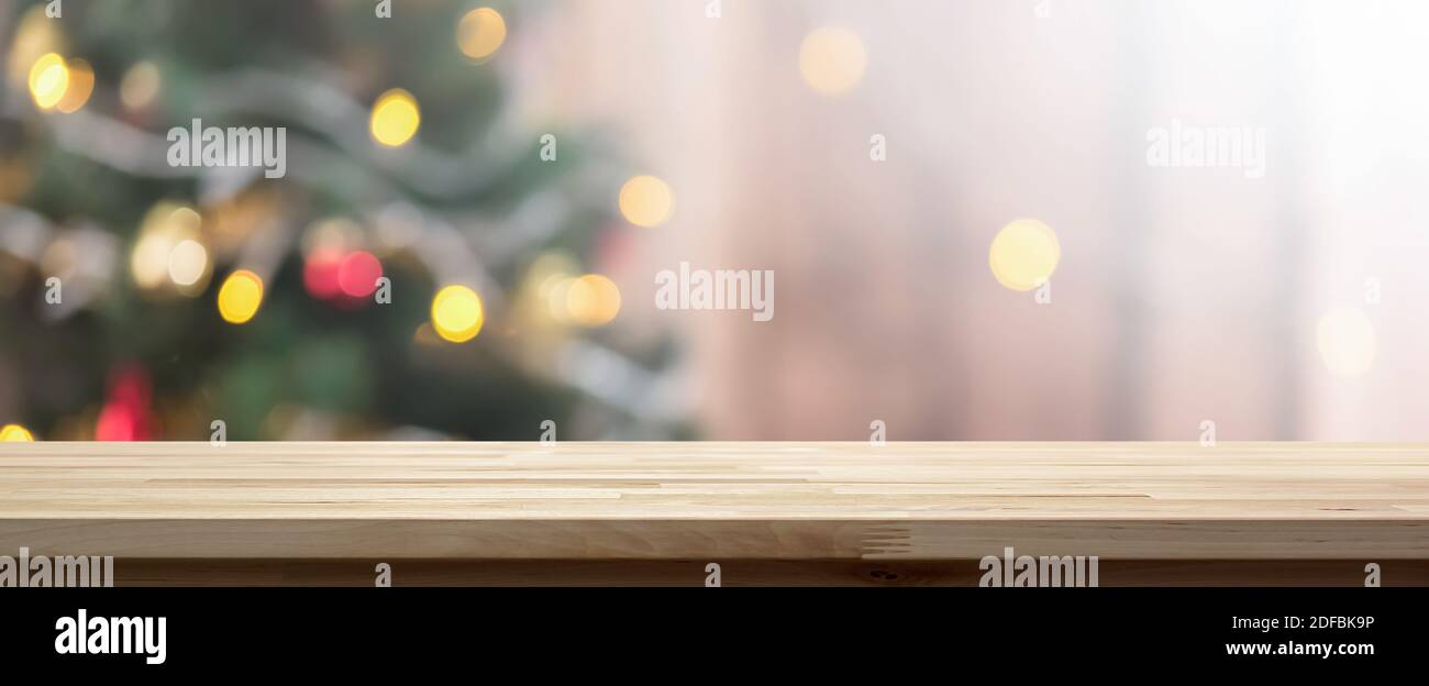 Holztischplatte auf buntem Bokeh Hintergrund aus dekorierten Weihnachtsbaum, Panorama-Banner - kann zur Anzeige oder Montage Ihrer Produkte verwendet werden Stockfoto