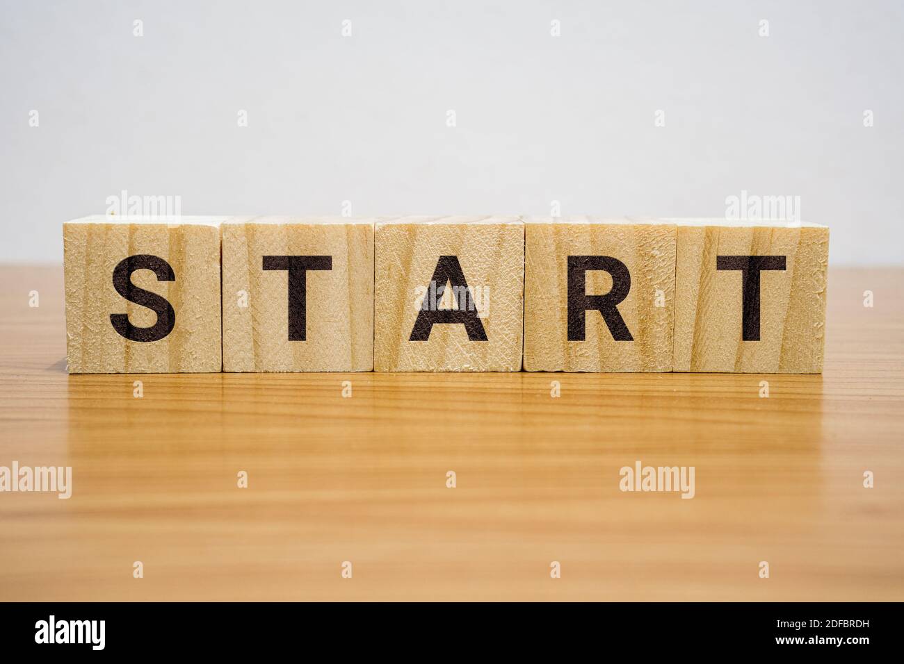 Holzblock auf dem Schreibtisch mit dem Wort Start. Stockfoto