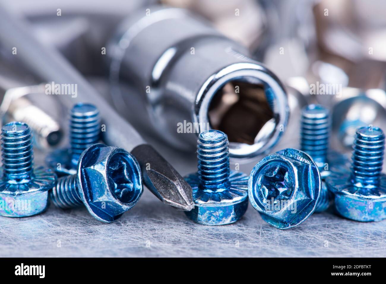 Werkzeuge und Satz Schraube auf metallischem Tischmakro Stockfoto