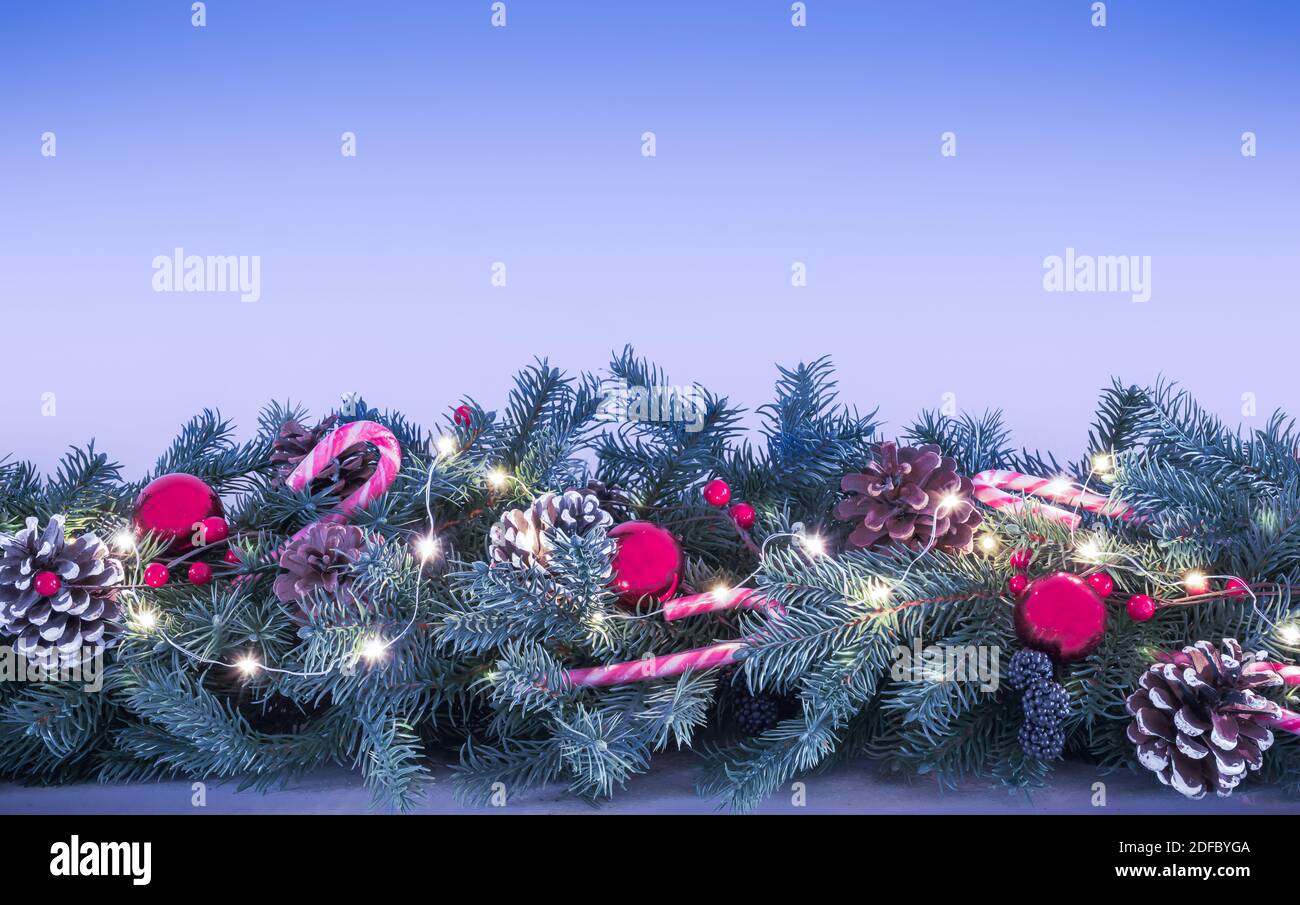 Girlande mit Weihnachtsschmuck auf blauem Hintergrund. Stockfoto