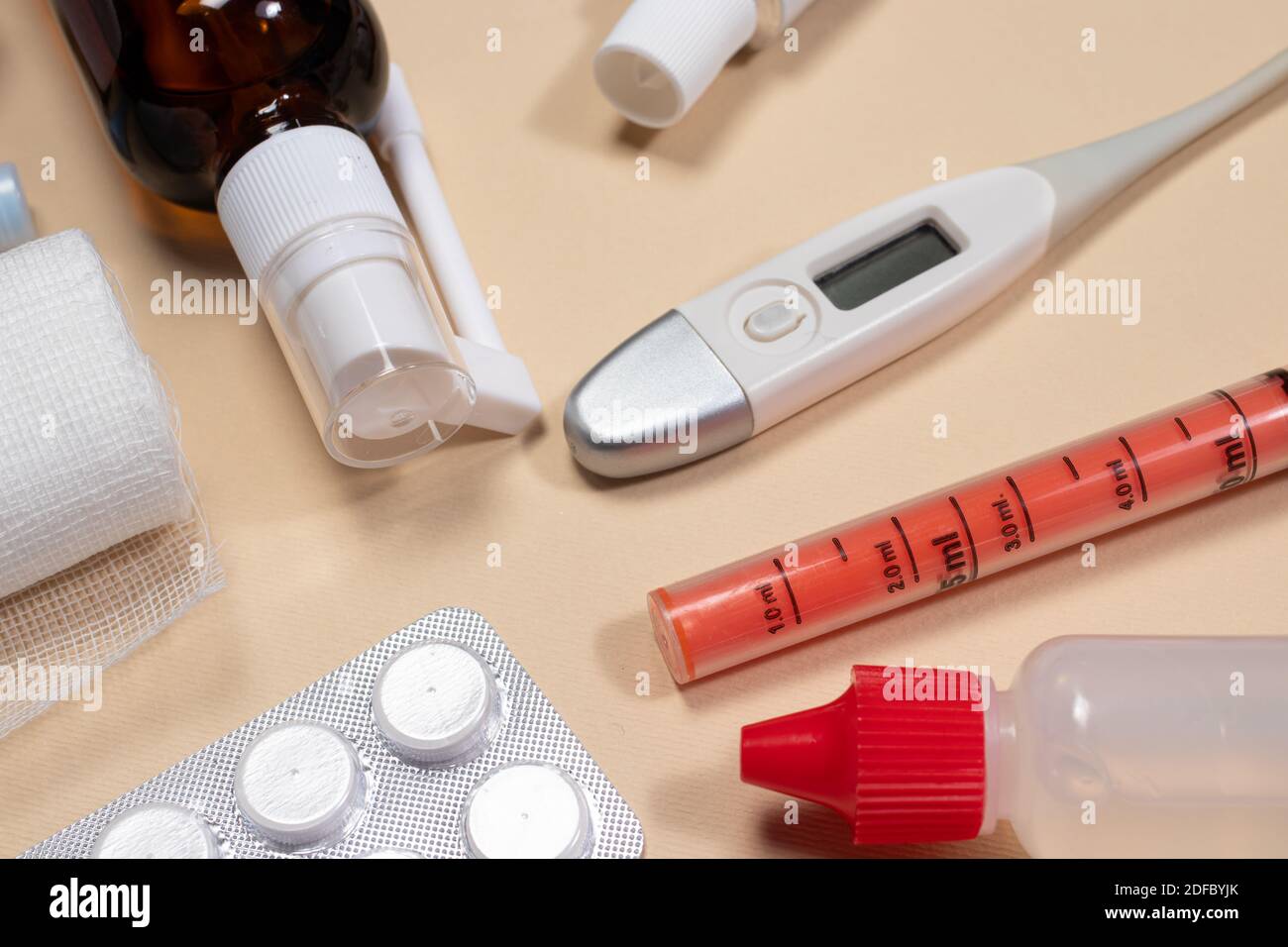 Verband, Medikamentenflaschen, Pillen und Thermometer auf hellbeigem Hintergrund. Fotos für Medizin und Pharmazie. Stockfoto