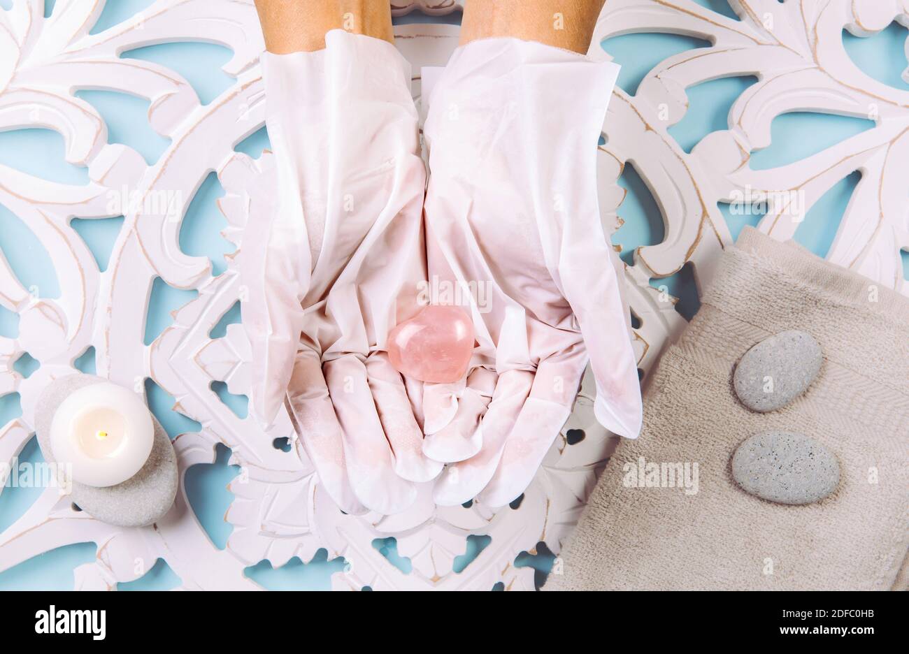 Nahaufnahme der Frau tragen zu Hause verwenden feuchtigkeitsspendende Handschuhe Maske Hexe können Ihre Hände weich und hydratisiert zu halten. Weiße Handschuhe Hände. Stockfoto