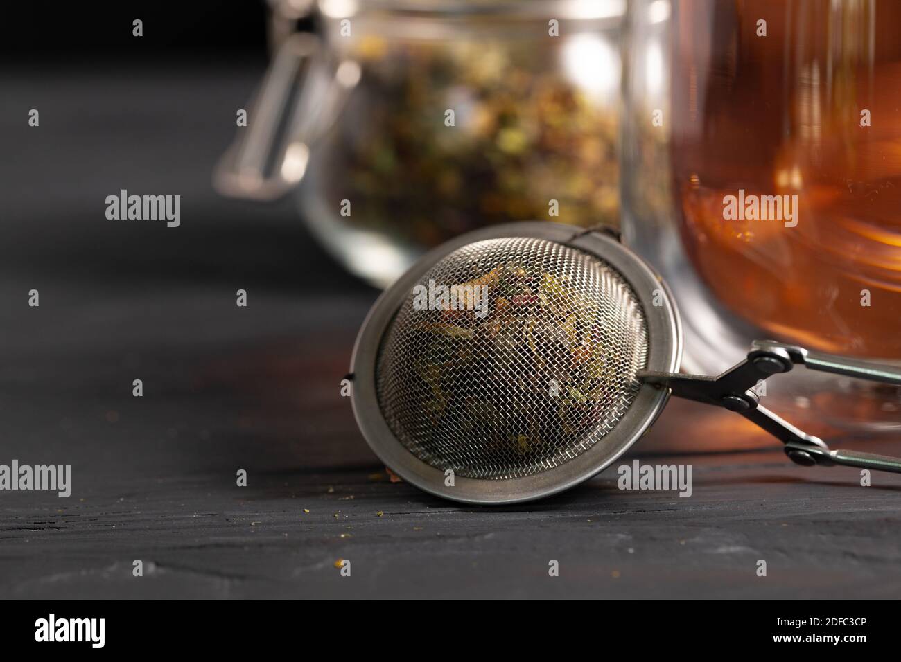 Teesieb aus Metall auf schwarzem Holztisch Stockfoto