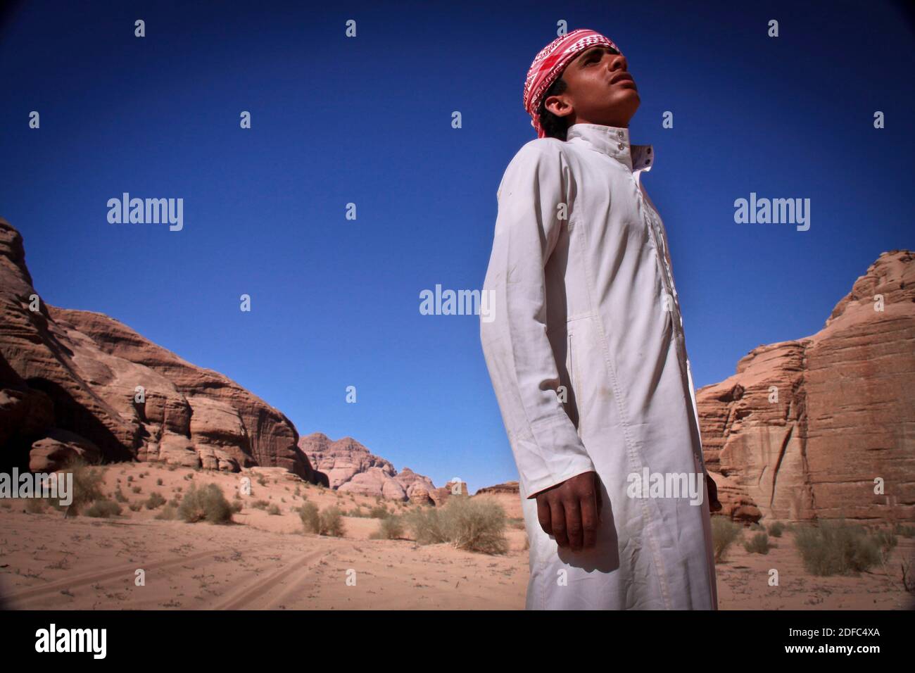 Jordanien, Porträt eines jungen Beduinen-Mannes in der Wadi Rum Wüste mit traditionellem weißen Kleid Stockfoto