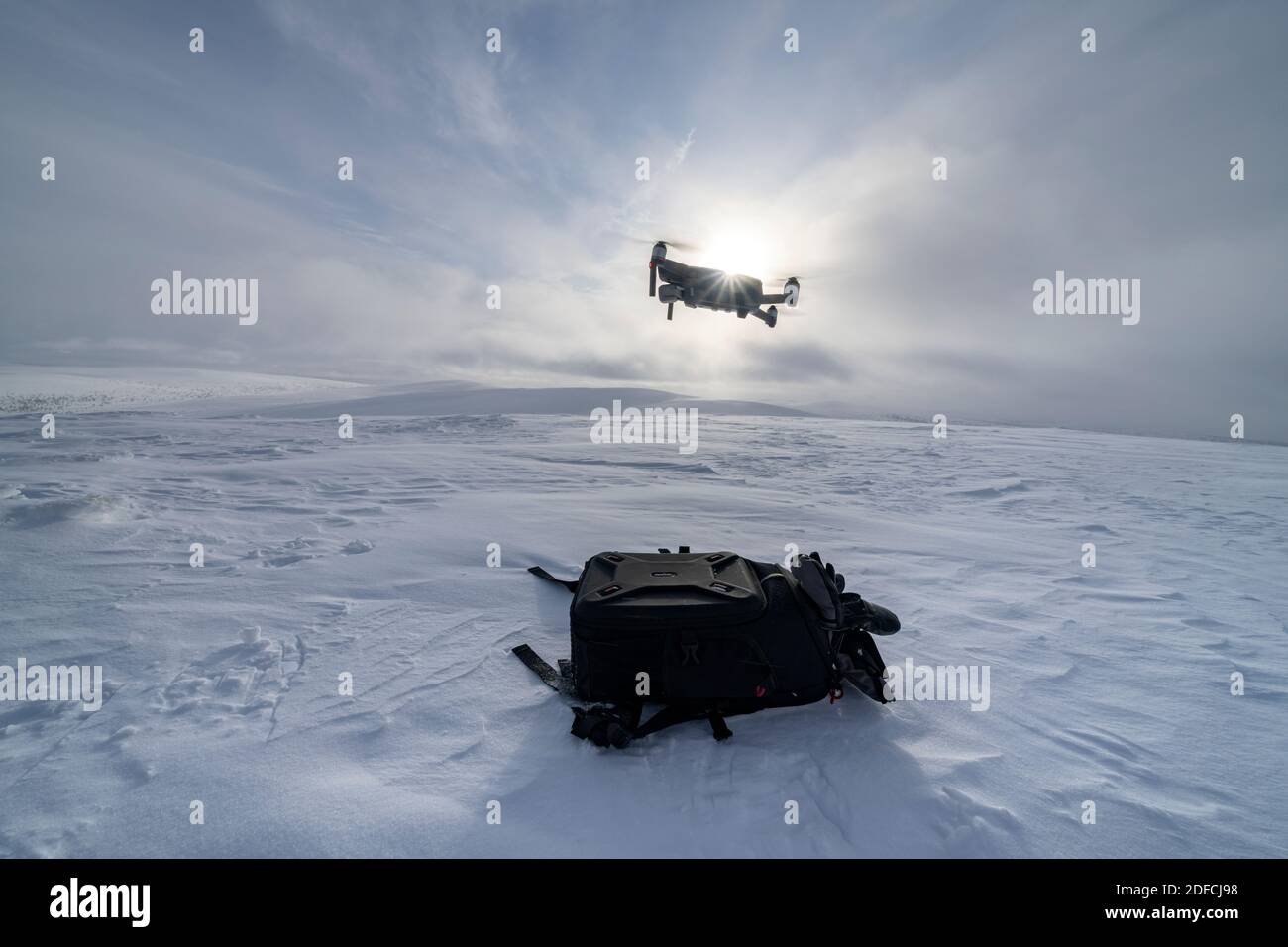 Drohne fliegt in die Wintersonne über die verschneiten Hügel des Urho-Kekkonen-Nationalparks, Saariselka, Inari, Lappland, Finnland Stockfoto