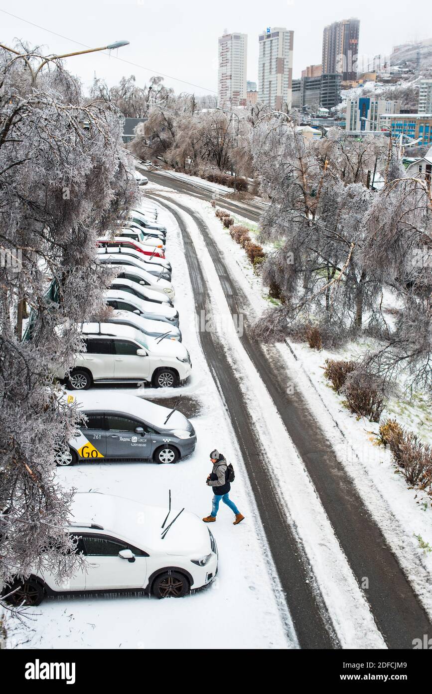 Blick auf die Stadt und die Straßen bei schlechtem Schneewetter. Autos mit Eis, Schnee und Eiszapfen bedeckt. Frostige Szenen im Winter. Eissturmzyklon. Stockfoto