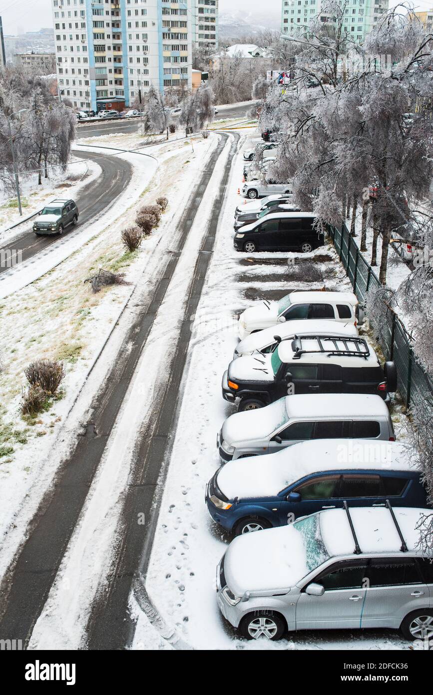 Blick auf die Stadt und die Straßen bei schlechtem Schneewetter. Autos mit Eis, Schnee und Eiszapfen bedeckt. Stadt im Winter. Eissturm und Zyklon. Stockfoto