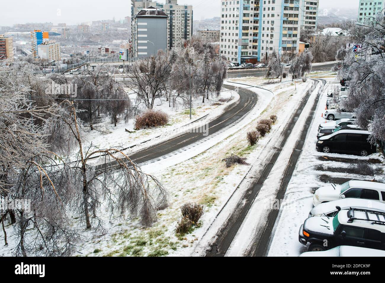 Blick auf die Stadt und die Straßen bei schlechtem Schneewetter. Autos mit Eis, Schnee und Eiszapfen bedeckt. Eissturmzyklon. Frostige Szenen im Winter. Stockfoto