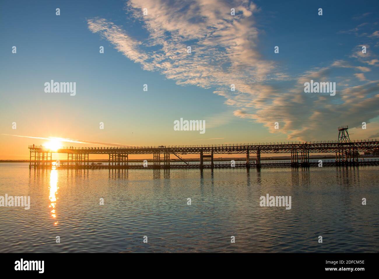 Sonnenuntergang am Mining Pier bekannt als Tinto Dock bei Sonnenuntergang 'Muelle del Tinto'. Dies ist einer der Überreste, die die Engländer in Huelva hinterlassen haben. Stockfoto