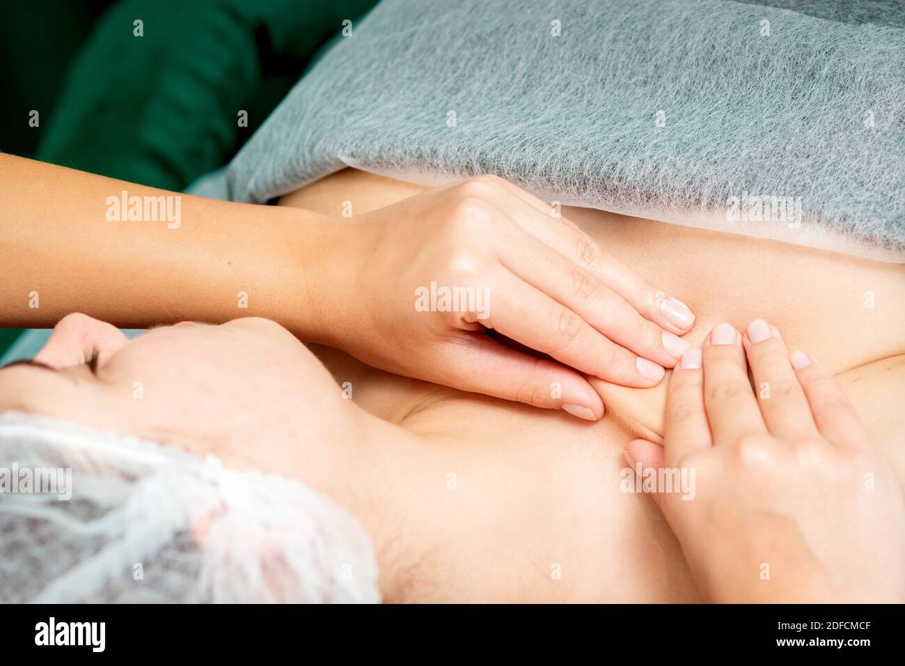 Nahaufnahme der jungen Frau erhalten Ausschnitt und Brust Massage