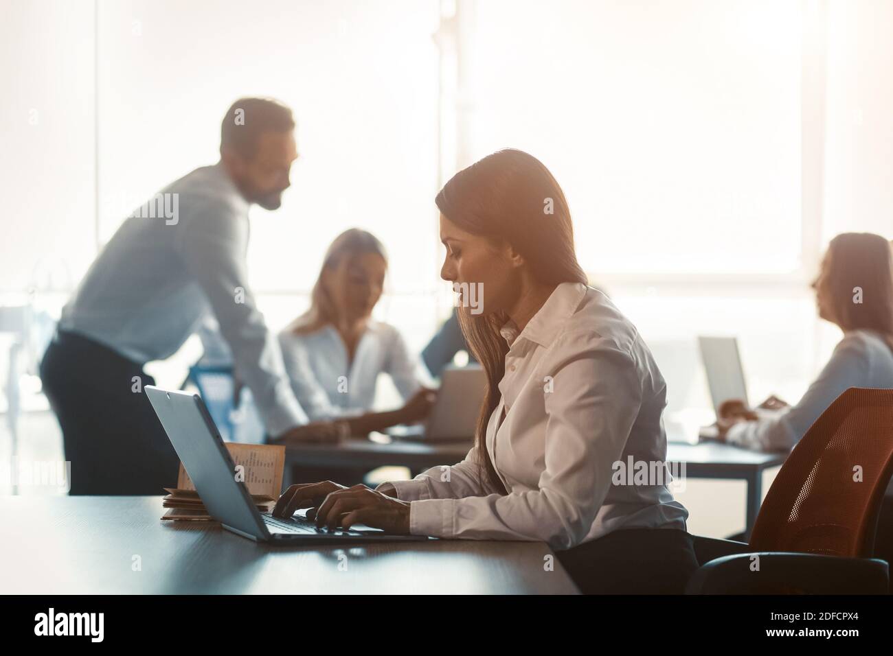 Führungskräfte arbeiten in Teamarbeit mit einer freiberuflichen Frau, die in einem modernen Büro am Arbeitsplatz mit einem Laptop arbeitet. Corporate Business Team Konzept Stockfoto