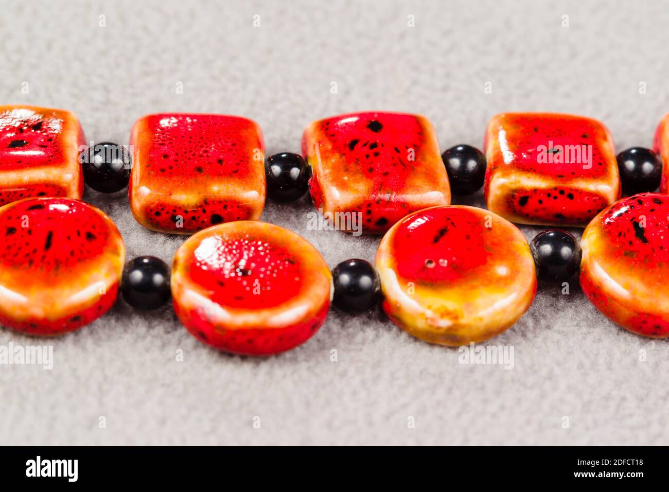 Ständer aus roten quadratischen und runden Perlen für die Kreation Von Schmuck Stockfoto