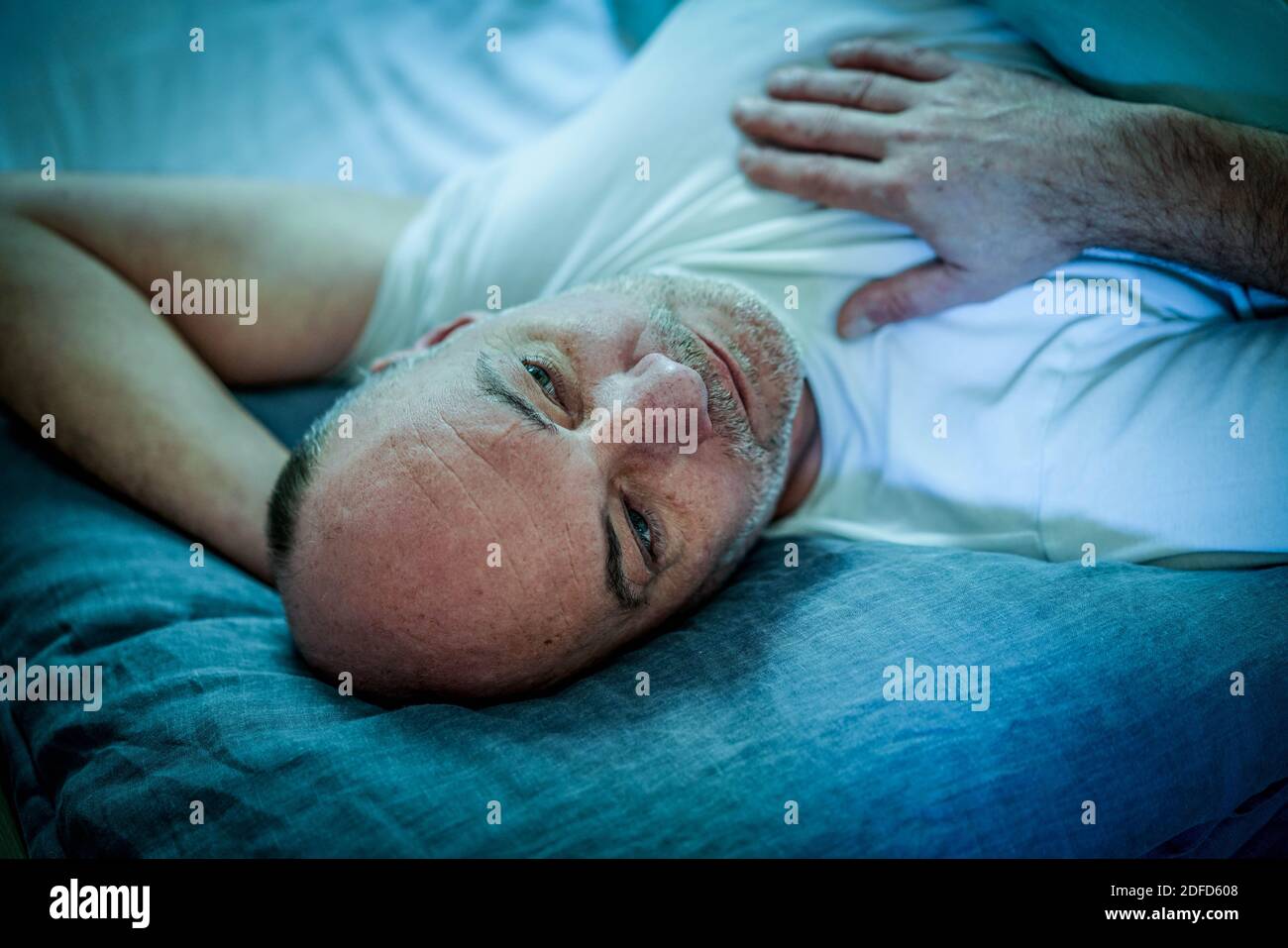 Mann liegt im Bett. Stockfoto