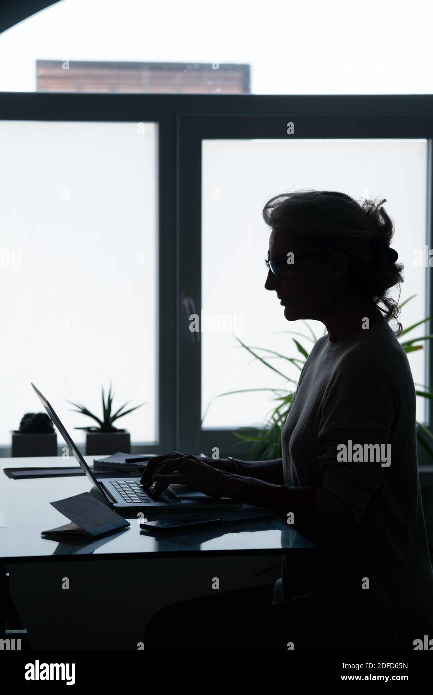 Ältere Geschäftsfrau mit Brille am Computer. Stockfoto