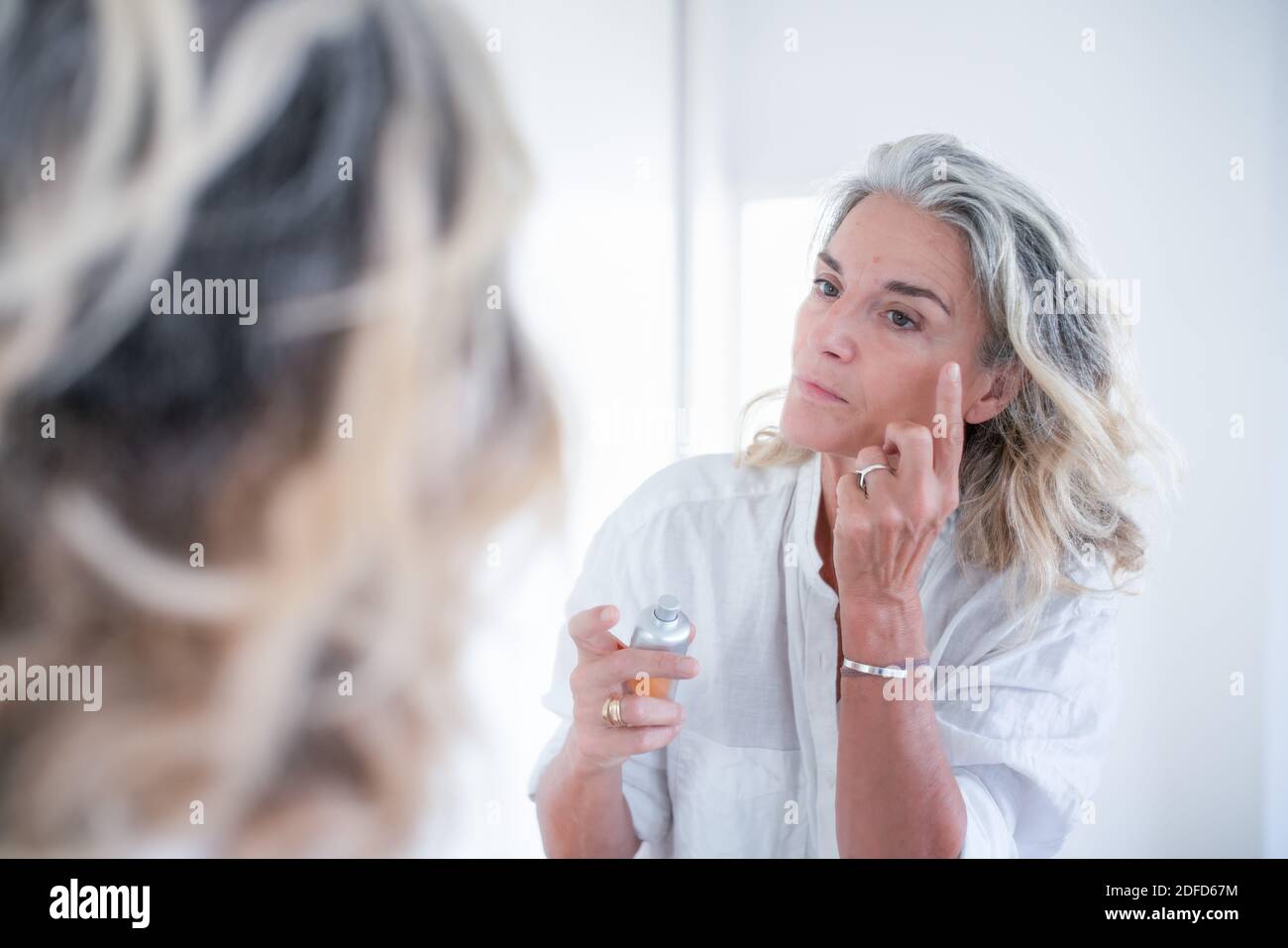 Frau Anwendung Feuchtigkeitscreme und Anti-Falten-Creme. Stockfoto