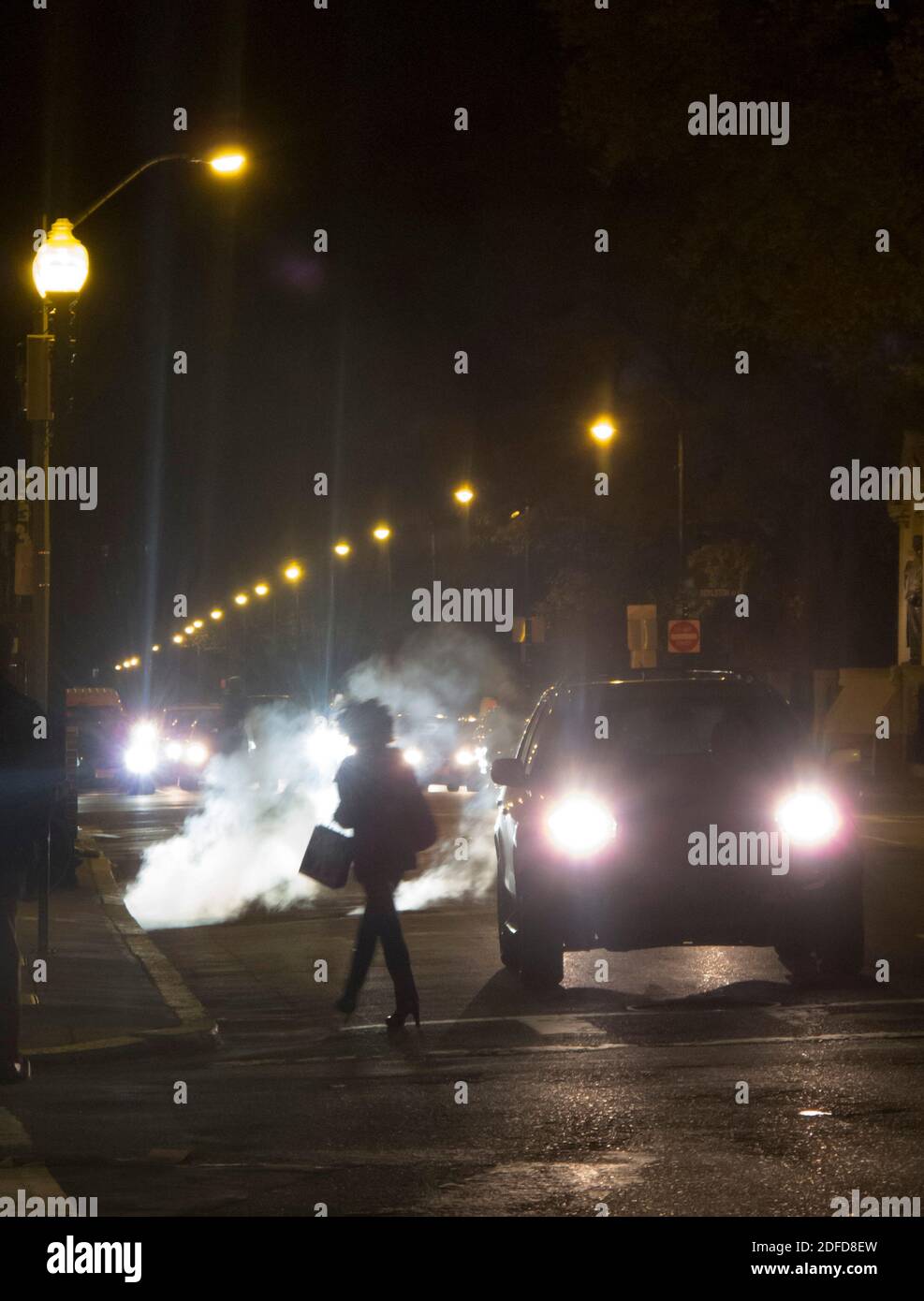 Afroamerikanische Dame mit Afro-Haaren überquert Arlington Street in Boston in der Nacht. Stockfoto