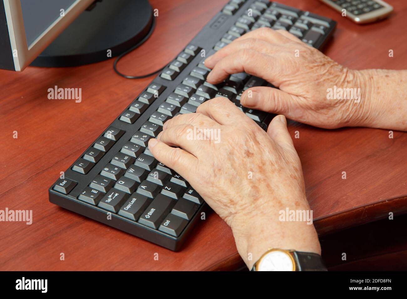 Nahaufnahme der Hand einer älteren Frau, die Tippt auf einer Computertastatur Stockfoto