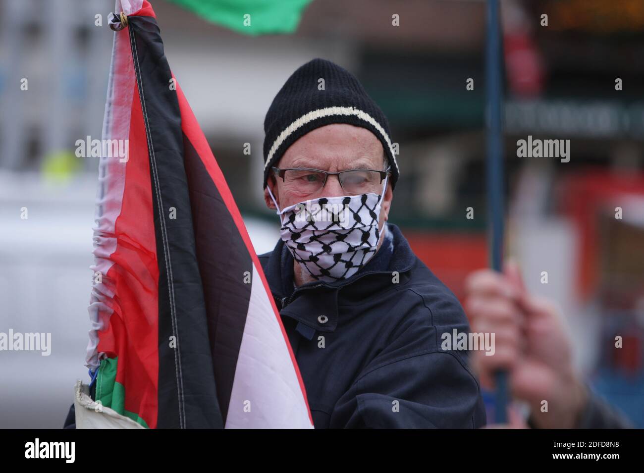 Amsterdam, Niederlande. Dezember 2020. Ein niederländischer Aktivist gegen den Krieg der ÔWomen in BlackÕ mit Schutzmaske hält während des Protestes ÔIsrael Stoppt die Besatzung' am Nieuwmarkt inmitten der Coronavirus-Pandemie am 4. Dezember 2020 in Amsterdam, Niederlande, eine palästinensische Fahne. Women in Black ist ein weltweites Netzwerk von Frauen, die sich für Frieden mit Gerechtigkeit einsetzen und sich aktiv gegen Ungerechtigkeit, Krieg, Militarismus und andere Formen von Gewalt einsetzen. (Foto von Paulo Amorim/Sipa USA) Quelle: SIPA USA/Alamy Live News Stockfoto