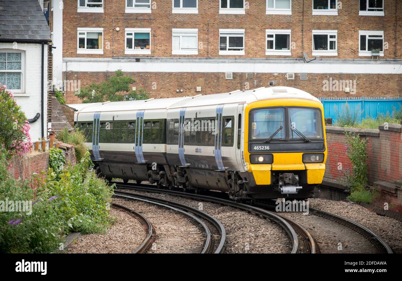 Personenzug der Klasse 465 in südöstlicher Lackierung, der durch ein urbanes Gebiet in England fährt. Stockfoto