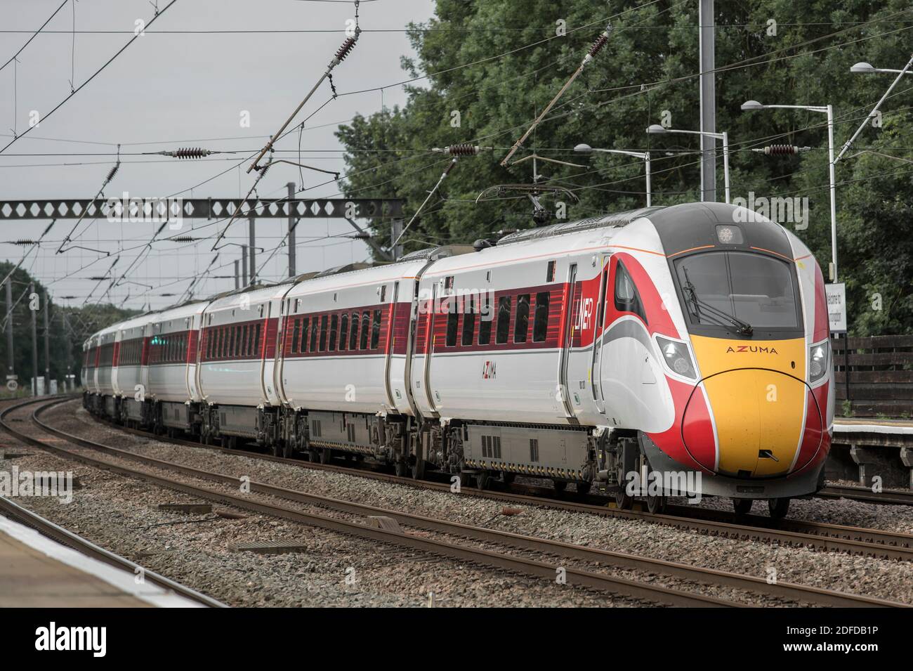 Azuma Hochgeschwindigkeitszug in LNER Lackierung Beschleunigung durch einen Bahnhof in Großbritannien. Stockfoto