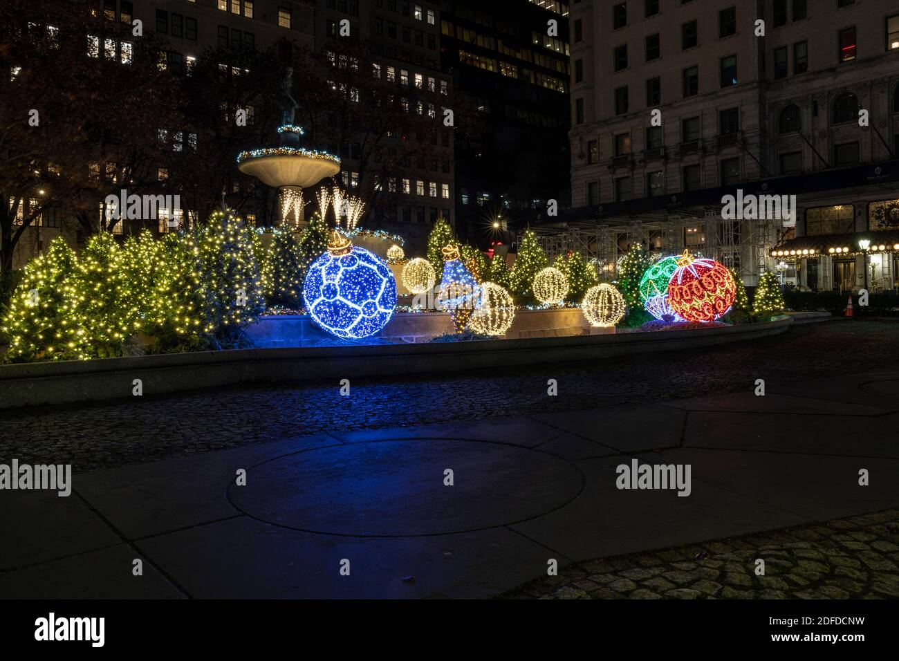 New York, NY - 3. Dezember 2020: Weihnachtsdekorationen überall in Manhattan, riesige Bälle auf Pulitzer Fountain auf der Fifth Avenue Stockfoto