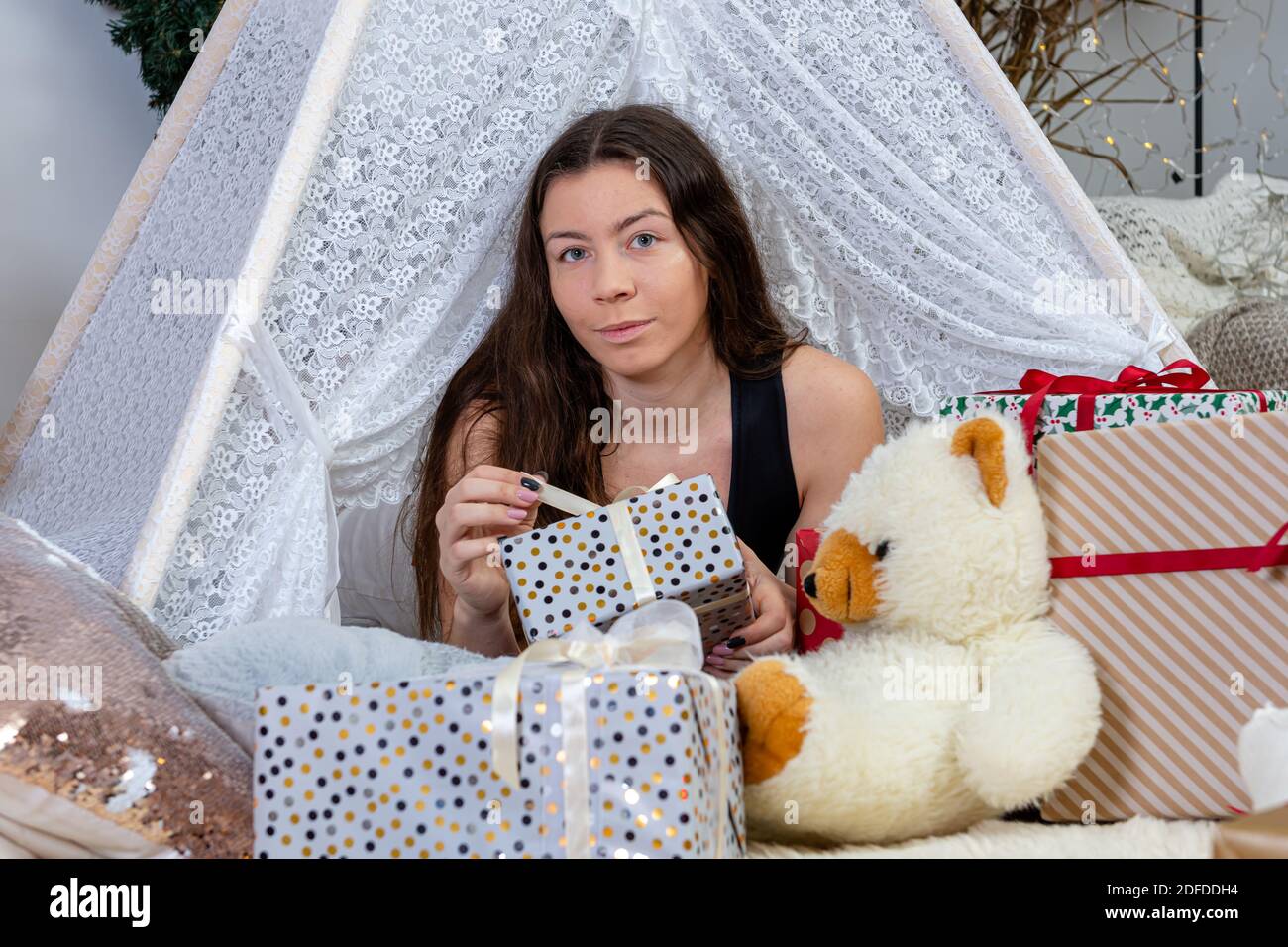 Brunette Teenager-Mädchen zwischen weihnachten Geschenk-Boxen und Spielzeug liegen, Weihnachtskonzept Stockfoto