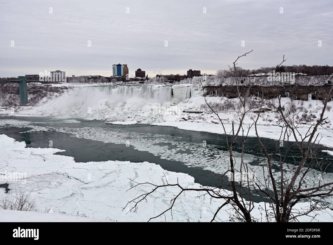 Blick über Bridal Veil Falls und die USA von der kanadischen Seite der Niagara Falls im Winter nach Schneefall. Eisbrocken treiben entlang des Flusses. Stockfoto