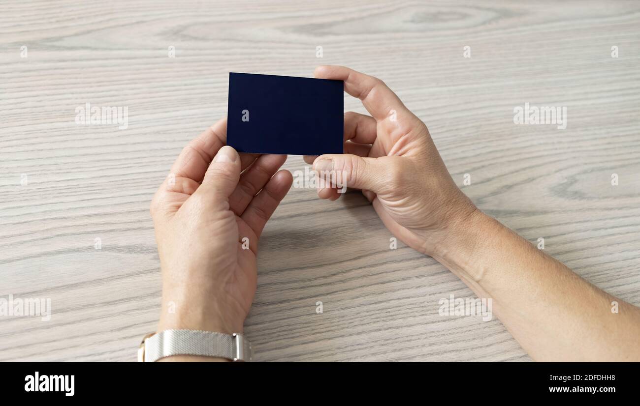Nahaufnahme der Hände einer Person, die einen schwarzen hält Visitenkarte ohne Logos Stockfoto