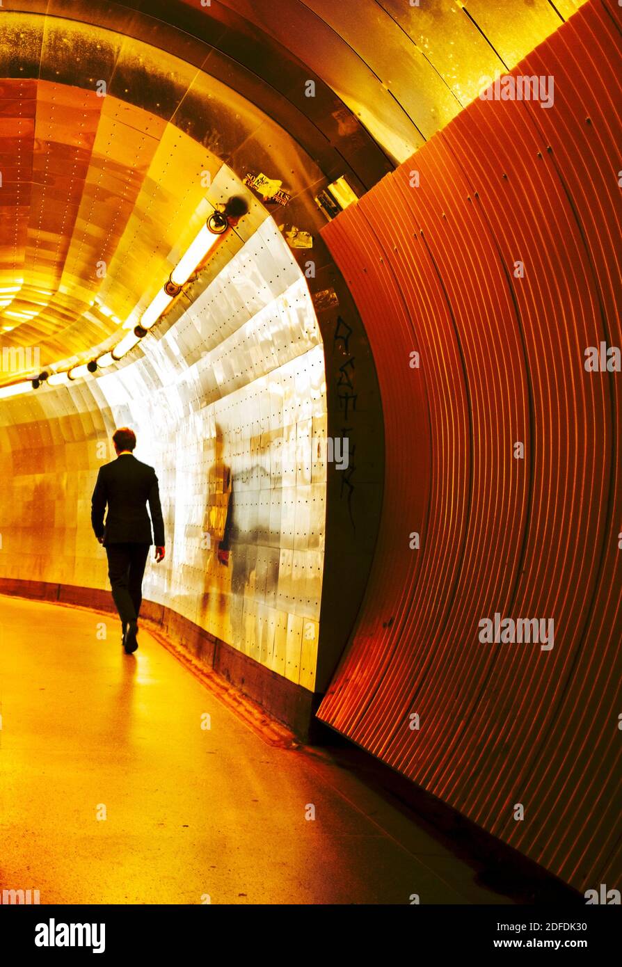 Mann im Geschäftsanzug, der in einem modernen Tunnel hereinläuft Stockholm Stockfoto