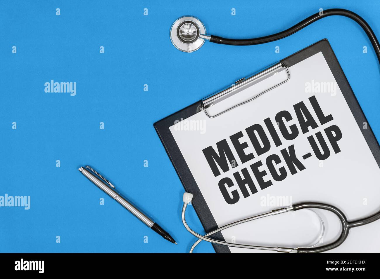 Medizinische Überprüfung. Overhead-Ansicht von Stethoskop und Zwischenablage auf blauem Hintergrund Stockfoto