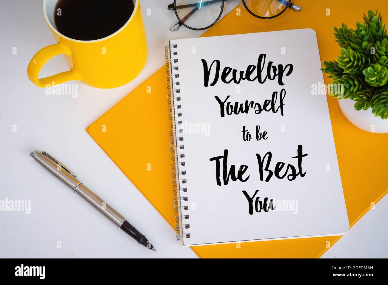 Kaffeebecher und Notizbuch mit inspirierenden und motivierenden Zitate. Stockfoto