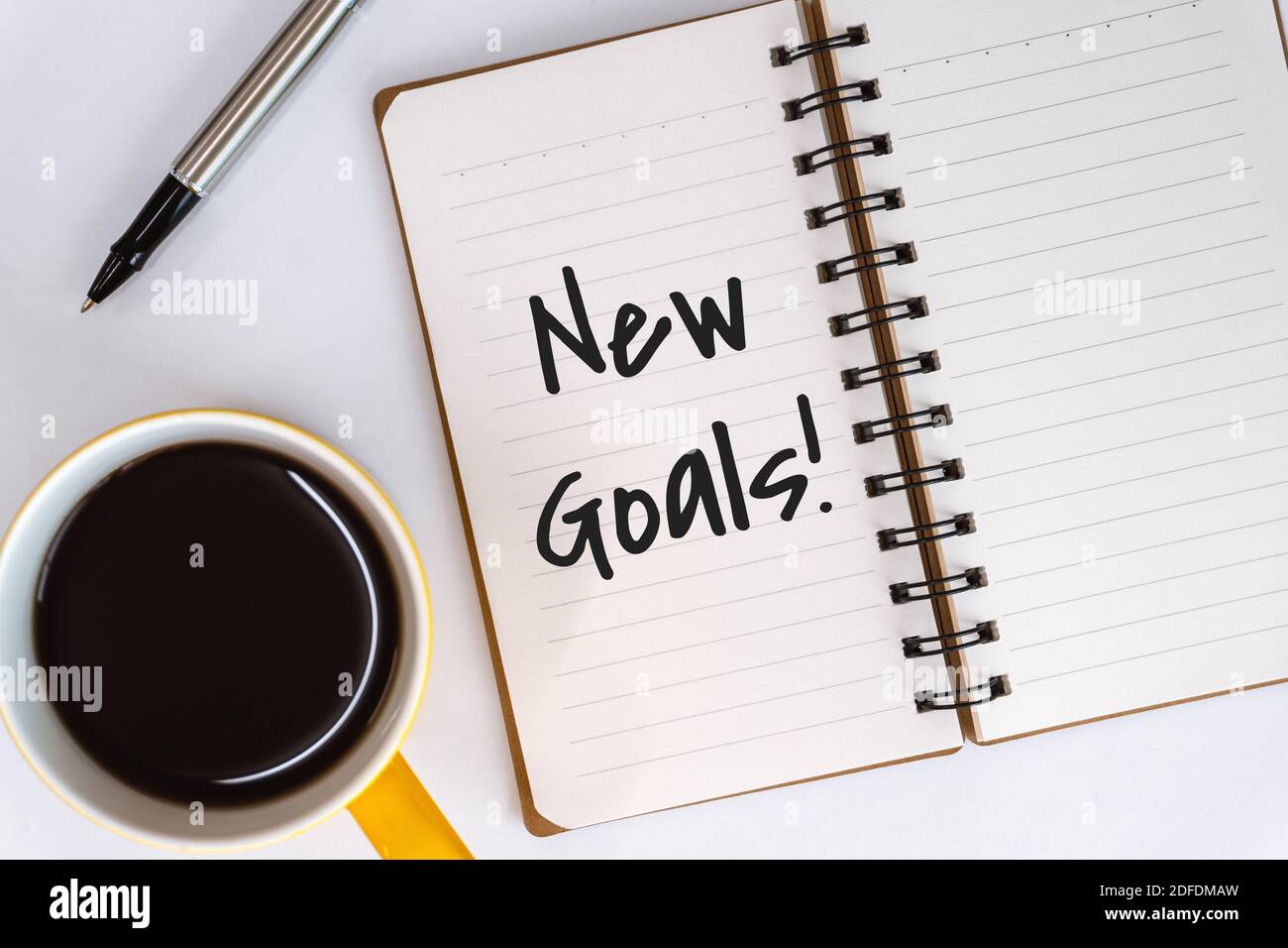 Neue Ziele. Spiral Notebook mit inspirierenden und motivierenden Angeboten auf White Desk. Stockfoto