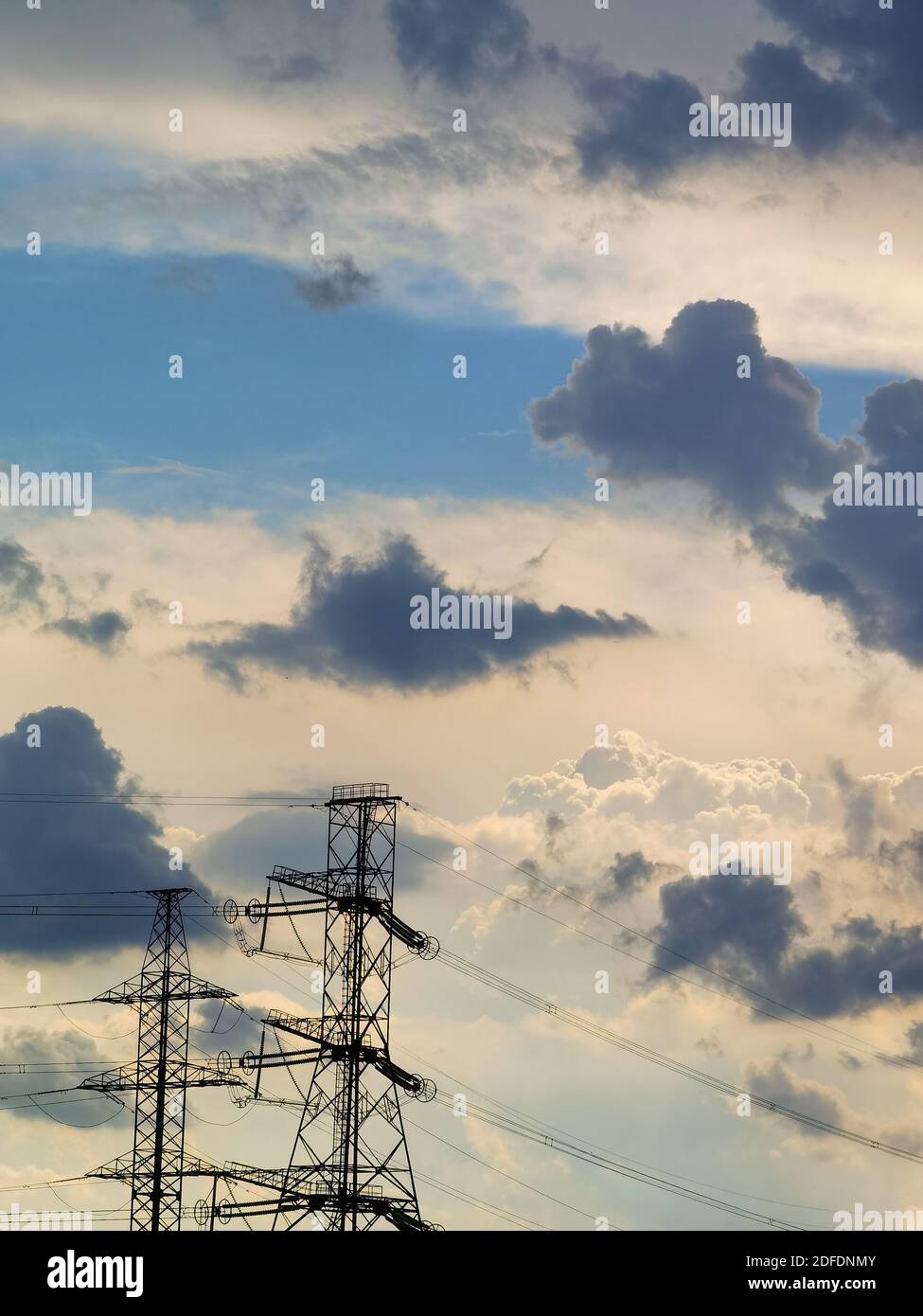 Hochspannungsleitungen unter blau bewölktem Himmel mit viel Platz für Text und Text Stockfoto