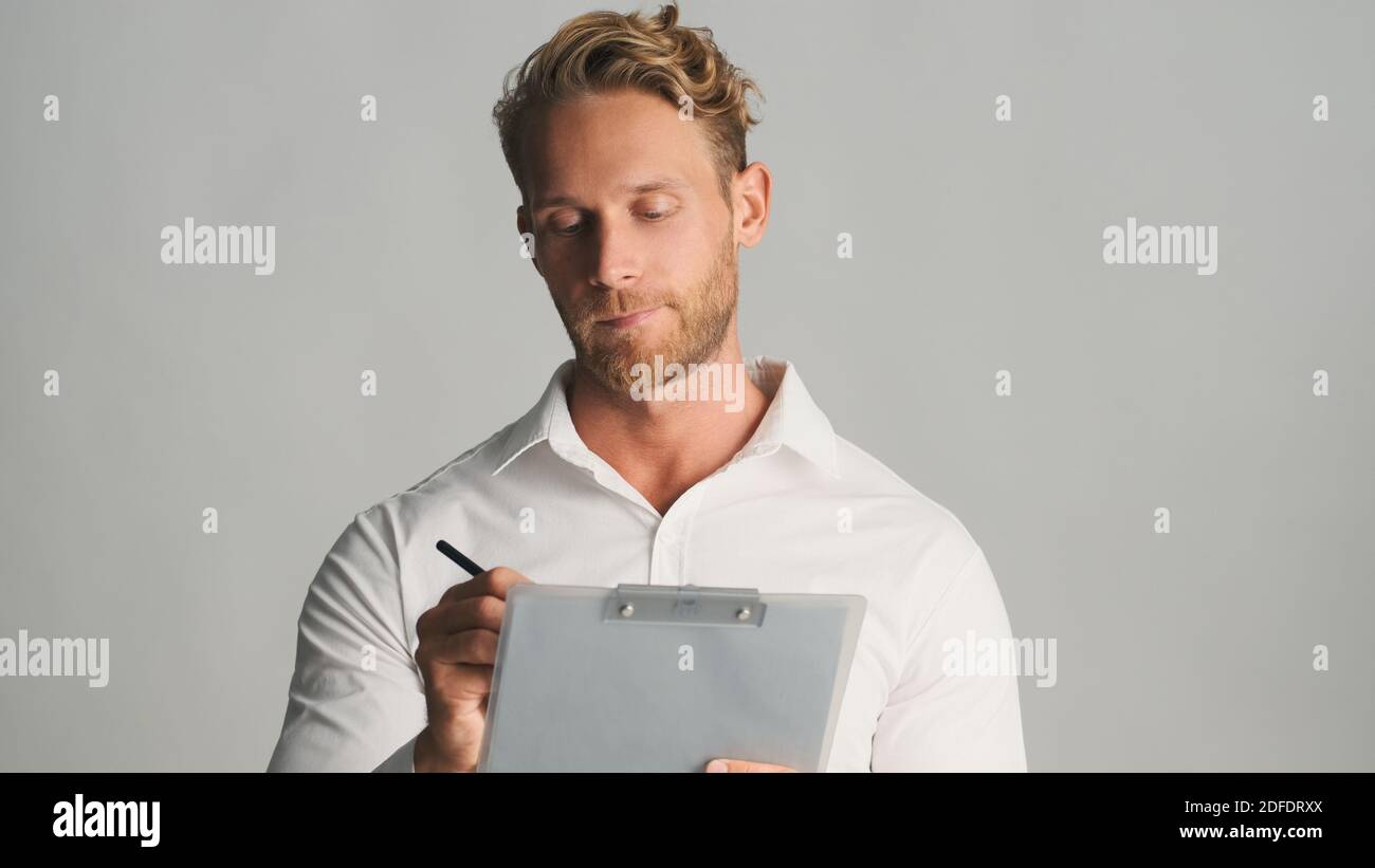 Gut aussehend konzentriert bärtigen Geschäftsmann im Hemd intensiv mit Dokumenten über weißem Hintergrund arbeiten. Geschäftskonzept Stockfoto