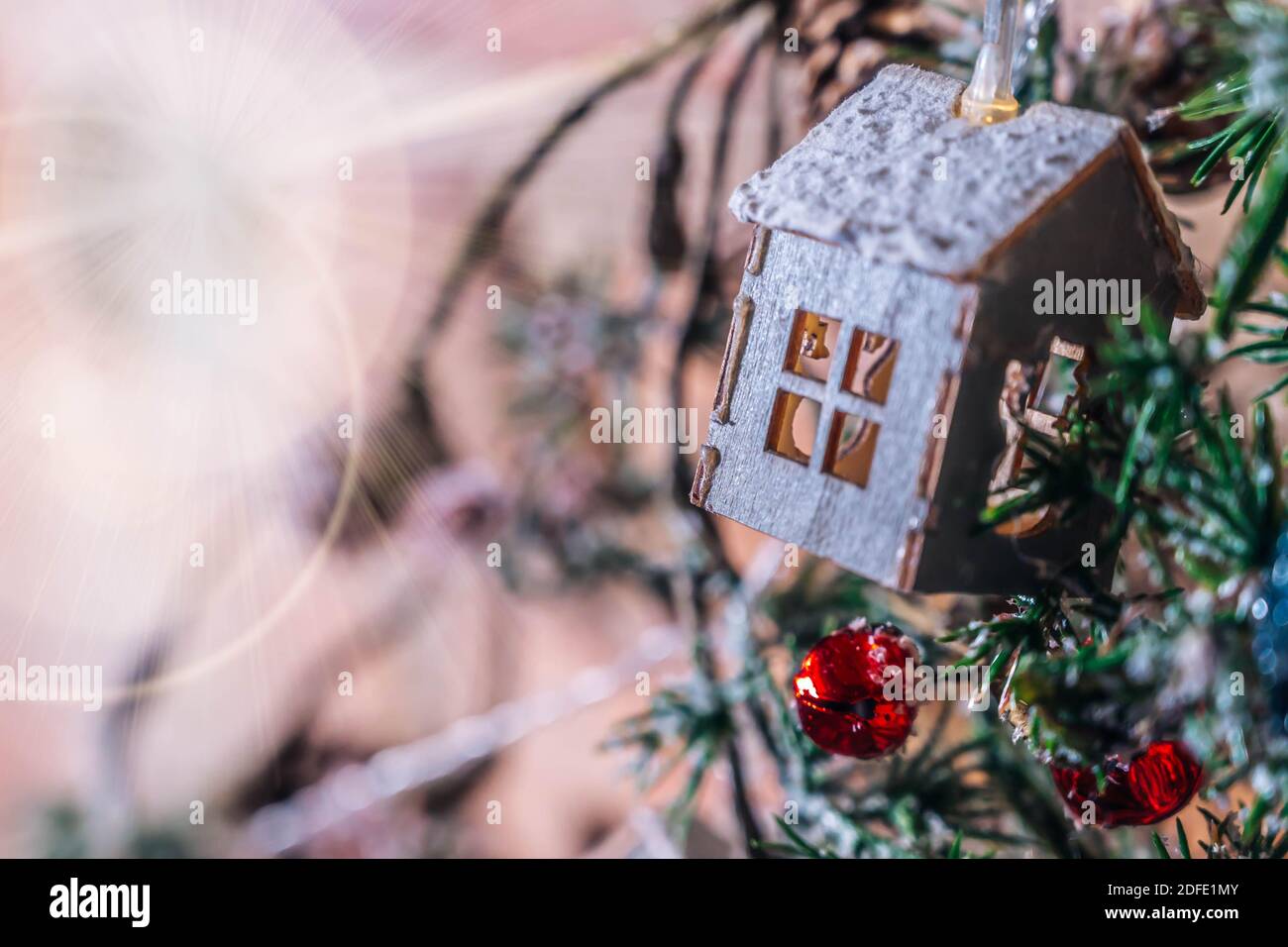 Dekorative Weihnachtsgirlande in Form von Holzhaus close-up. Isoliert auf einem Backstein Wand Hintergrund. Weihnachten oder Neujahr Hintergrund. Stockfoto