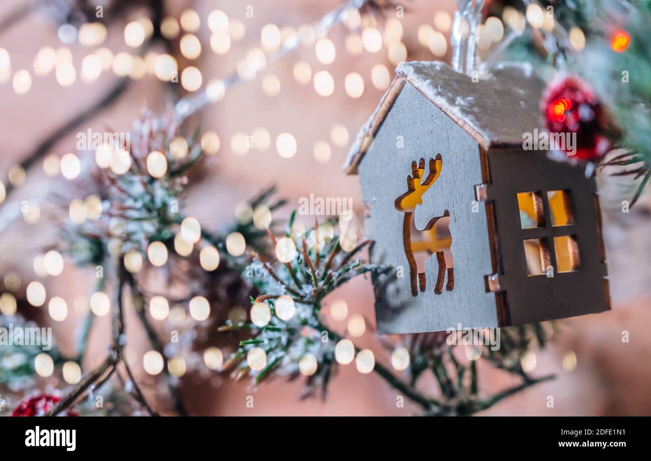 Dekorative Weihnachtsgirlande in Form von Holzhaus close-up. Isoliert auf einem Backstein Wand Hintergrund. Weihnachten oder Neujahr Hintergrund. Stockfoto