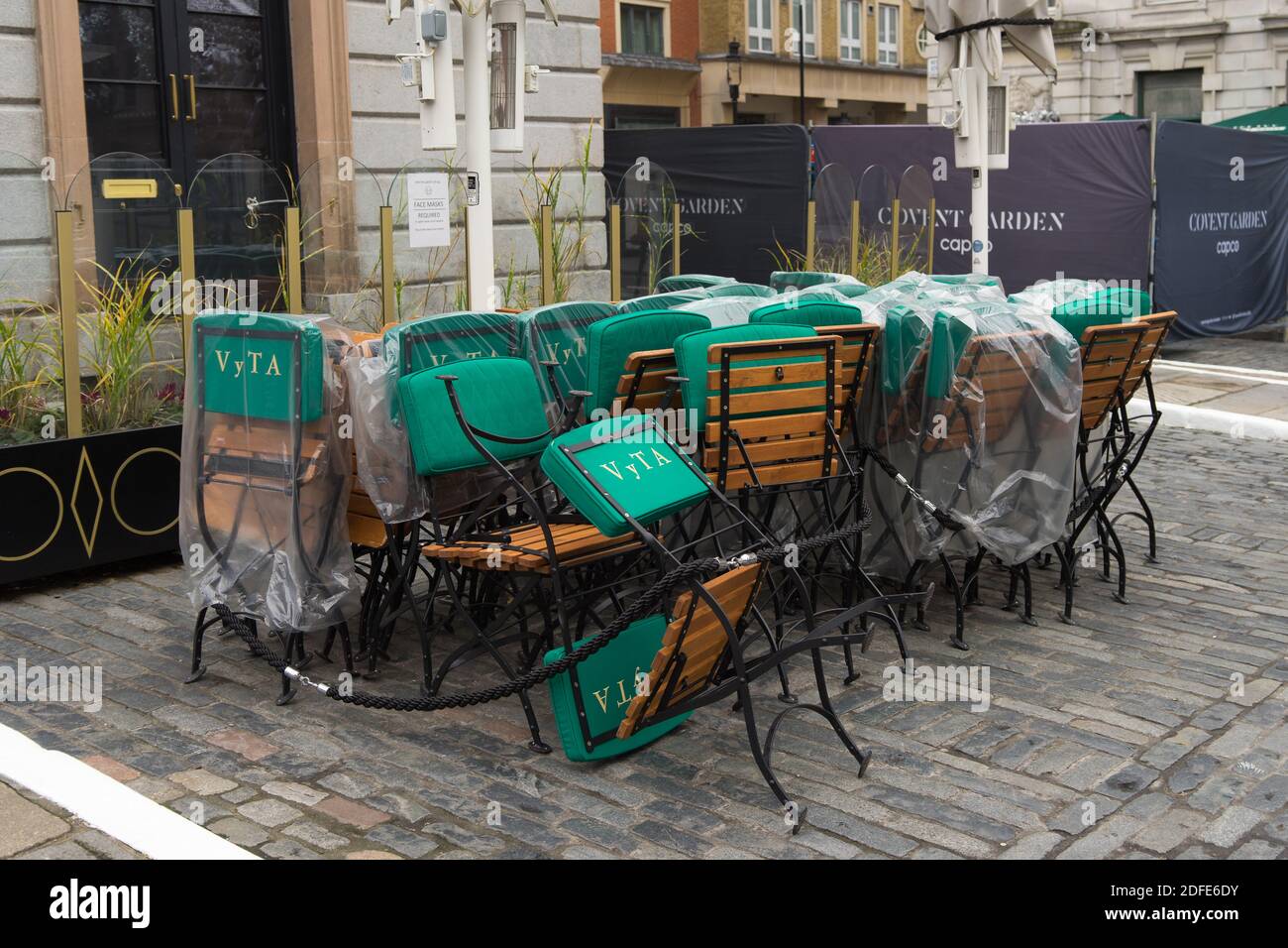 Gestapelte Stühle und Tische vor einem Restaurant in Covent Garden. London Stockfoto